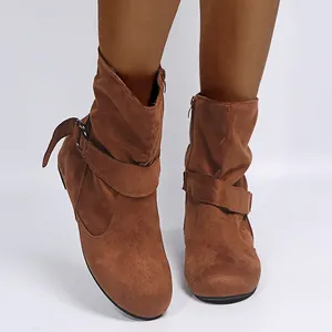 Nahaufnahme brauner Wildleder-Stiefeletten mit dekorativem seitlichem Schnallenriemen