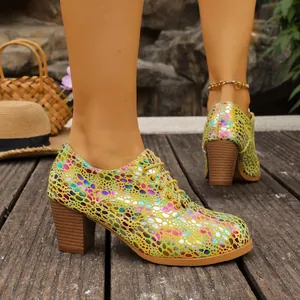 Close-up of yellow lace-up chunky heel pumps with colorful dot patterns on wooden floor