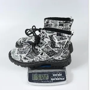 Detailansicht der bedruckten Martin-Stiefel, die auf einer Digitalwaage gewogen werden
