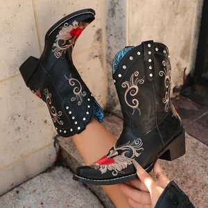 Detailed view of black embroidered Western cowboy boots with red heart and gold swirls
