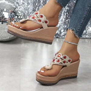 Detalle de sandalias de cuña con pedrería roja y perlas para mujeres a la moda