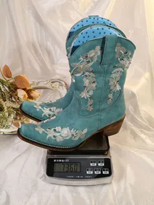 Detailansicht des Gewichts von türkisfarbenen Cowboy-Stiefeln auf einer Digitalwaage.