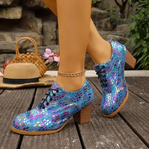 Close-up of vibrant blue iridescent chunky heel lace-up shoes worn on a model