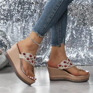 Primer plano de sandalias de cuña con pedrería, gemas rojas y suela de plataforma