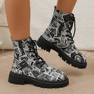 Nahaufnahme von Stiefeletten mit Zeitungsdruck, dicken Sohlen und schwarzen Schnürsenkeln.