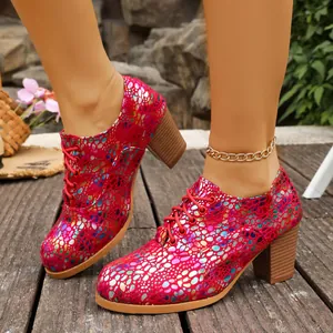 Side view of red sparkly lace-up high heels with chunky heels on a wooden deck