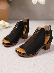 Detailansicht schwarzer Cut-Out-Römersandalen mit mittelhohem braunem Blockabsatz