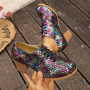 Close-up detail of colorful bubble pattern lace-up chunky heel shoes on wood deck