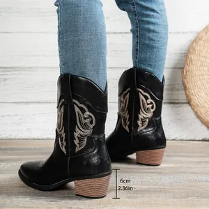 Détail de bottes de cowboy brodées noires avec un talon épais de 6cm et coupe en V