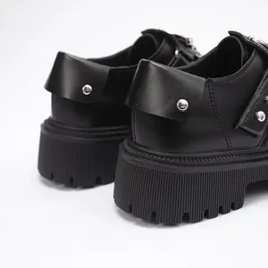 Detailed macro view of black platform shoes with silver rivets and chunky lug soles