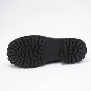 Close-up detail view of the durable thick rubber sole with deep tread on a black leather shoe