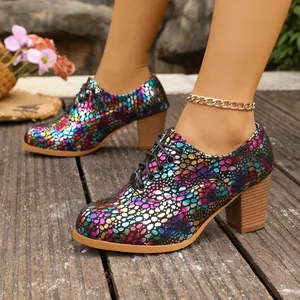 Detail view of stylish block heel shoes with a colorful metallic scale pattern and laces.