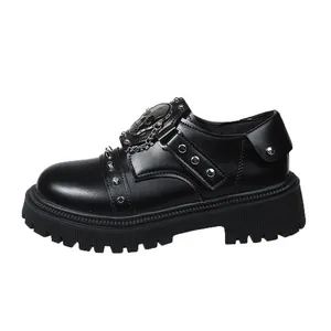 Detailed view of gothic black platform loafer featuring skull emblem, studs, and chain accent