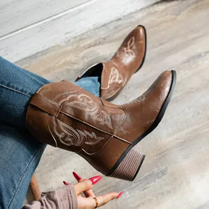 Vue détaillée de bottes de cowboy brodées marron avec talon épais et col en V rétro.