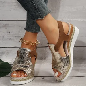 Gros plan de sandales compensées en espadrille argentée avec bout ouvert sur modèle.