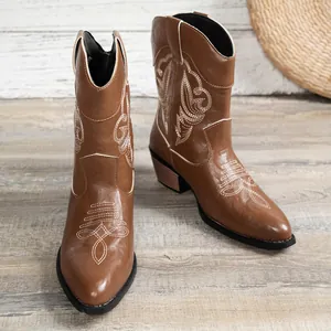 Détail de bottes de cowboy western marron avec broderie blanche et coupe en V.