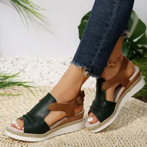 Gros plan de sandales à talons compensés en cuir vert et marron pour femmes, style été.