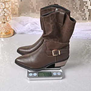 Macro view of dark brown western mid-calf boots on a scale showing 700g weight detail