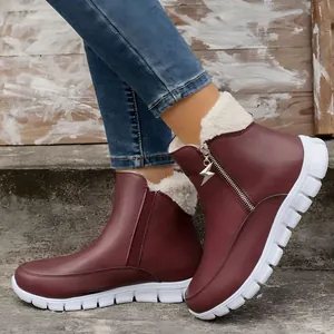 Close-up detail of stylish burgundy women's winter snow boots with warm fleece lining and zipper
