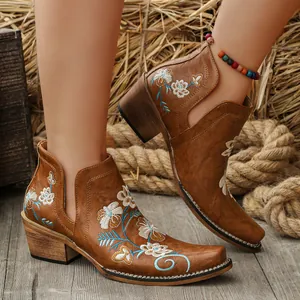 Detail view of brown western boots with floral embroidery and chunky heels