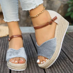 Gros plan de sandales compensées en tissu gris avec plateforme en jute tressée