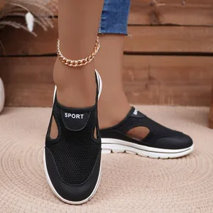Detailed close-up of black mesh slip-on mules with white thick sole and sport logo