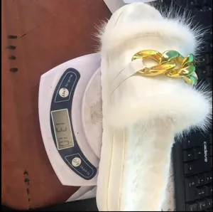 Pantofola in ecopelliccia bianca con grossa catena dorata, peso 131g su bilancia digitale