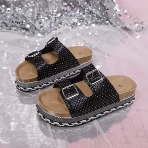 Black cork platform sandals with double buckles and sparkling rhinestone accents.