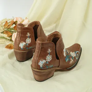 Close-up of vintage brown women's western ankle boots with floral embroidery details