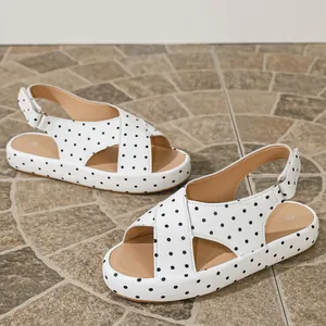 Detailed view of women's white polka dot sandals with soft soles and adjustable straps.