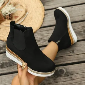 Modische Chelsea-Stiefeletten mit Keilabsatz aus schwarzem Wildleder auf rustikalem Holz