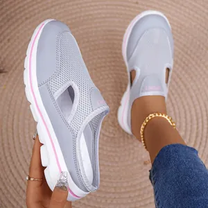 Close-up of grey mesh mules with thick white soles and pink trim accents