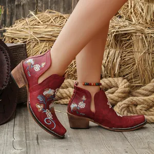 Detailed view of vintage red western ankle boots with floral embroidery and chunky heels.