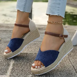 Gros plan de sandales compensées espadrilles pour femmes en tissu bleu et bride