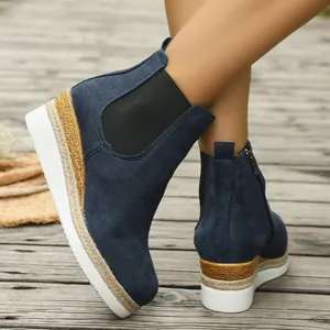 Detailansicht von dunkelblauen Wildleder-Keilstiefeletten mit Plateau-Gummisohle