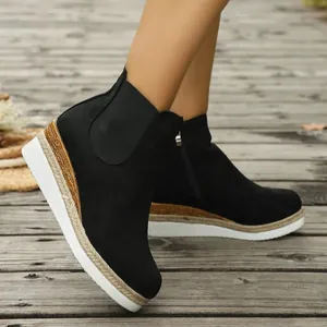 Nahaufnahme schwarzer Keilstiefeletten für Damen mit geflochtenem Sohlendetail aus Wildleder.