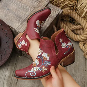 Detailed view of vintage red western ankle boots with floral embroidery and chunky heel