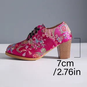 Macro view of the 7cm chunky heel on these vintage floral satin embroidered lace-up boots