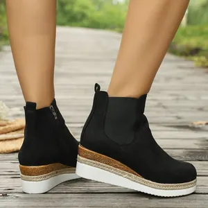 Detailansicht von schwarzen Wildleder-Plateau-Stiefeletten mit gewebter Sohle.