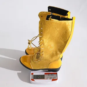 Detailansicht gelber bestickter Stiefel auf einer Digitalwaage mit Gewicht von 0,536 kg