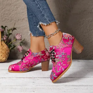 Close-up of vibrant fuchsia satin floral embroidery on vintage chunky heel lace-up shoes