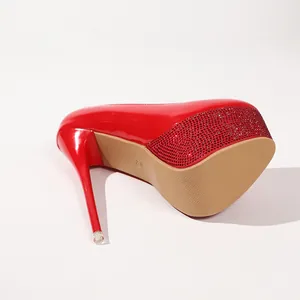 Detailaufnahme eines roten Plateauschuhs aus Lackleder mit glitzerndem Strassbesatz