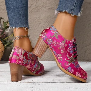 Macro view of vintage magenta floral embroidered satin ankle boots with wooden chunky heels