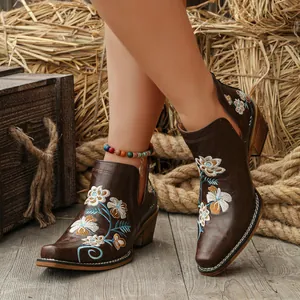 Detailed view of floral embroidery on brown western square toe ankle boots with V-cut.