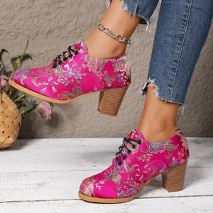 Close-up of retro satin embroidered high-heeled shoes with floral patterns and chunky heels