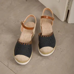 Vista dettagliata dei sandali con zeppa blu navy da donna con cinturini marroni