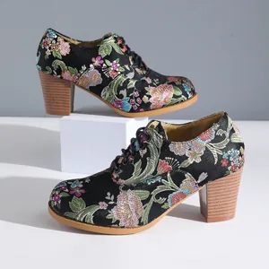 Detailed view of vintage floral embroidered chunky high heels with lace-up design