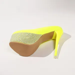 Detailaufnahme der neongelben Plateau-Pumps aus Lackleder mit Strassverzierung