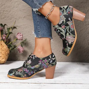 Detailed view of vintage floral embroidered satin lace-up boots with chunky wooden heels