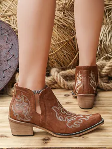 Detailed view of brown Western ankle boots with white floral embroidery and V-cut